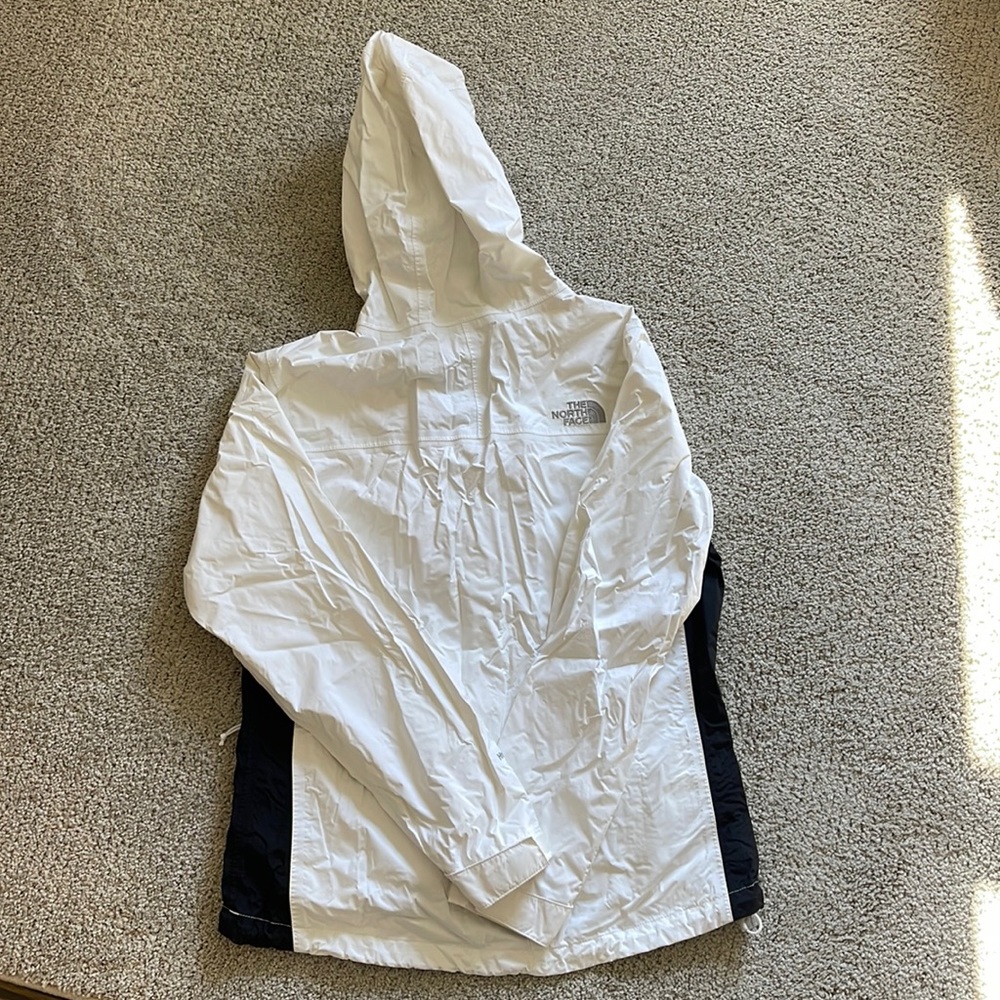White north face rain coat with black stripes. Apologies for wrinkles.